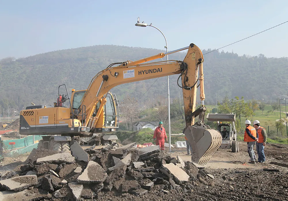 Excavadora con martillo hidráulico y equipo en terreno